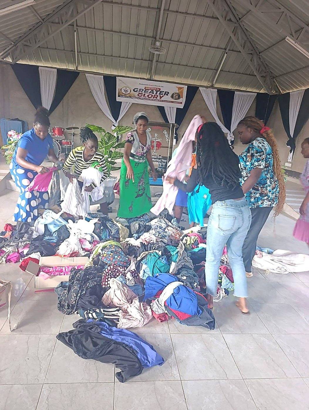 Volunteers sorting a large pile of donated clothes at a GCIG clothing drive