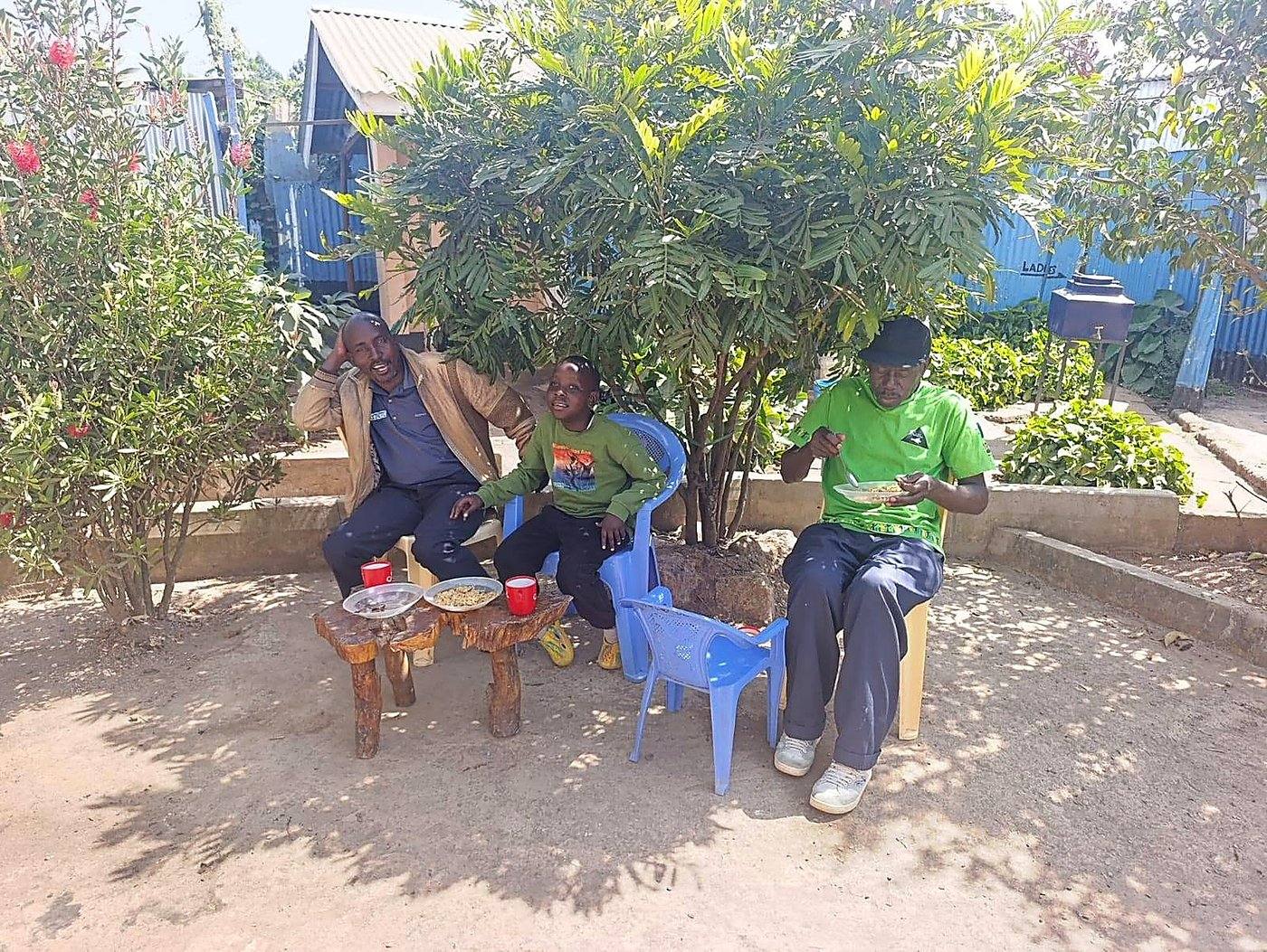 An outdoor community meeting under a tree